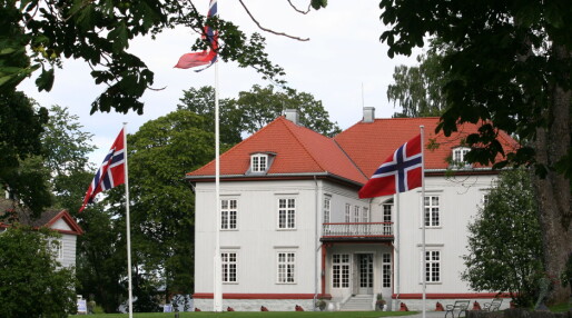 Heiser regnbueflagget foran Eidsvollsbygningen