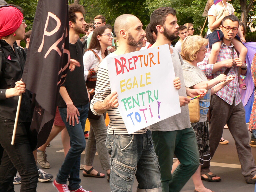En paradedeltaker holder en plakat med påskriften «Like rettigheter for alle!» under en prideparaden i den rumenske hovedstaden București i 2014. Det er anslått at 10 000 mennesker deltok i fjorårets parade.