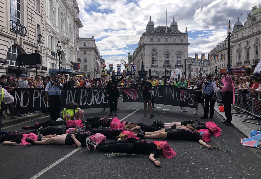 Mens flere titalls aktivister fra gruppa Lesbians and Gays Support the Migrants la seg ned i veien, kom andre aktivister fram med bannere der det sto «no pride in cops» og «no pride in borders». Mens flere titalls aktivister fra gruppa Lesbians and Gays Support the Migrants la seg ned i veien, kom andre aktivister fram med bannere der det sto «no pride in cops» og «no pride in borders».