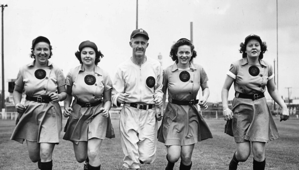 Rockford Peaches sine uniformer var passende nok ferskenfargede, men bukser ble kvinnene nektet å gå i. Kvinnene måtte konkurrere i skjørt og det var først etter en stund at de mannlige gründerne bak ligaen forsto at kvinnene hadde virkelig talent. Her er fire av kvinnene på laget avbildet med trener Bill Allington.