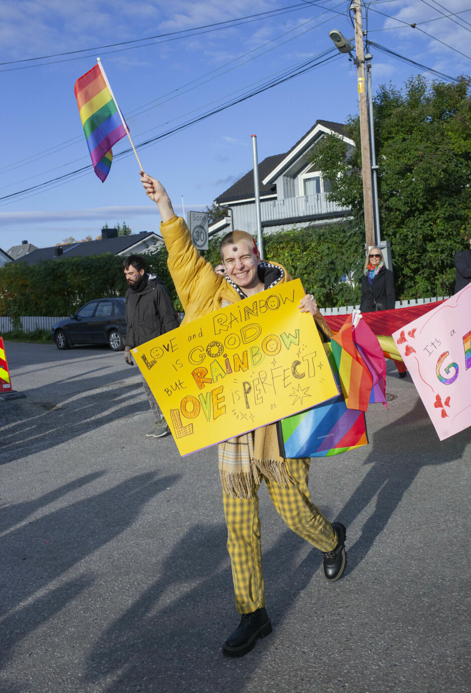 Lera vifter med et regnbueflagg i paraden som går igjennom Kirkenes sentrum.