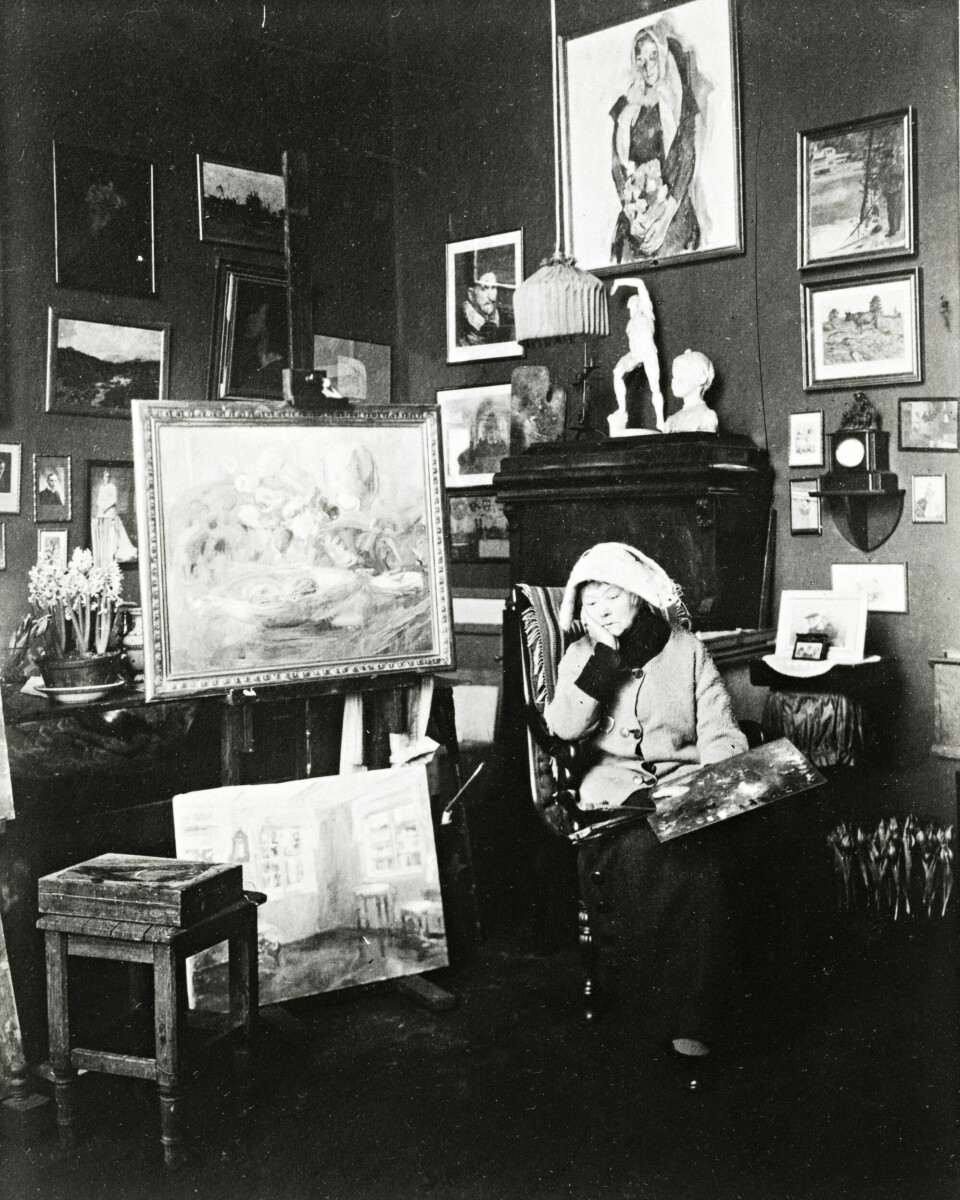 Harriet Backer i atelieret, ca. 1920. De siste årene gikk hun alltid med sitt hollandske hodeplagg, en gave fra nevøen Fridtjof Backer Grøndahl.