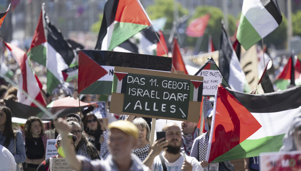 Propalestinske demonstranter holder opp en plakat der det står «Det 11. bud: Israel får gjøre som de vil».