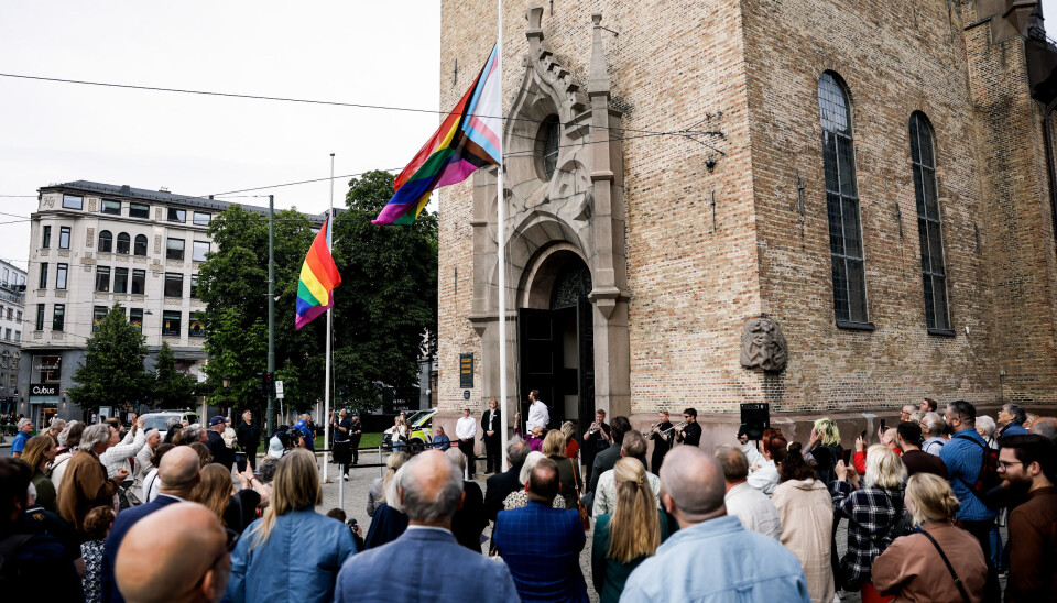 Oslobiskop Sunniva Gylver heiser regnbueflagget under åpningen av Oslo Pride 2025 foran Oslo domkirke.