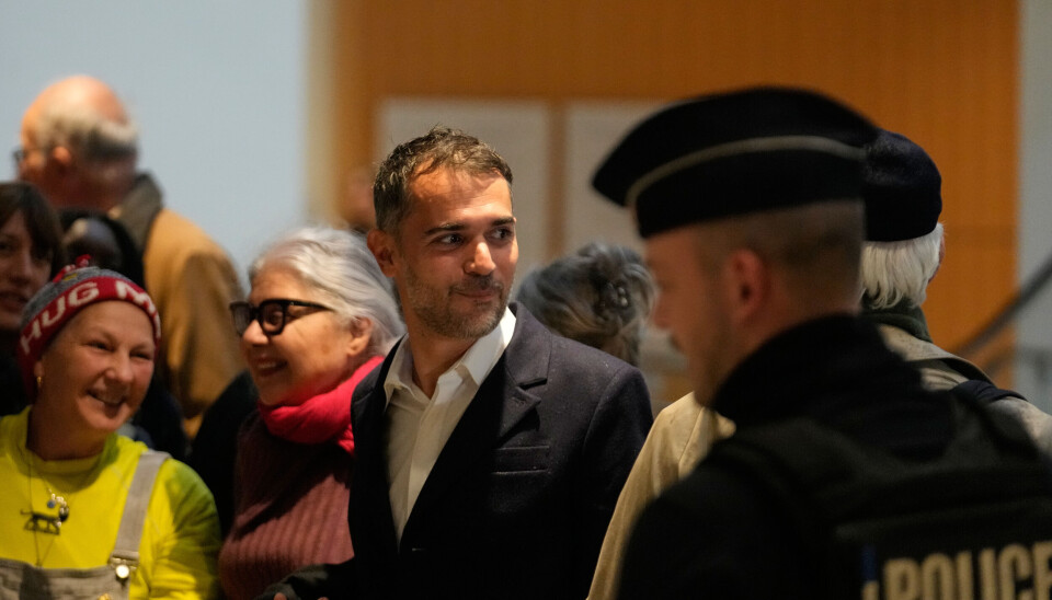 En av de tiltalte, Aurelien Poirson-Atlan (i midten), ankommer rettssalen mandag. Han og ni andre er tiltalt for å ha spredt ondsinnede rykter om Brigitte Macron.